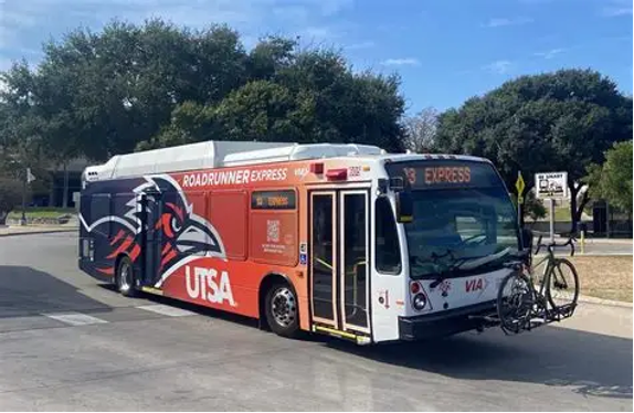 UTSA Roadrunner Express bus, labeled Route 93 Express, parked on campus with a bicycle mounted on the front bike rack