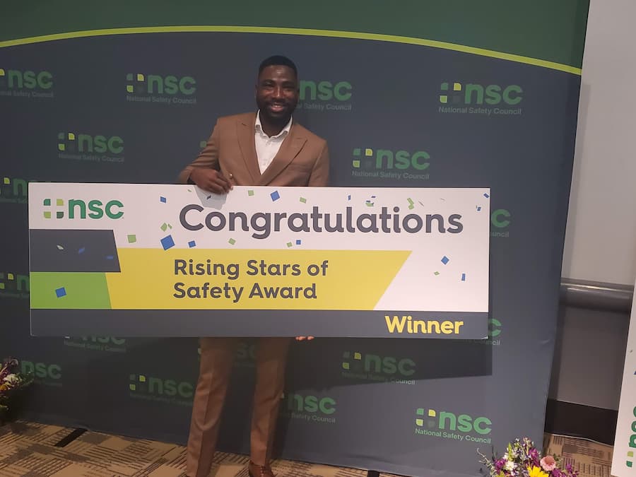 Ibukun holding a placard signaling his achievement.