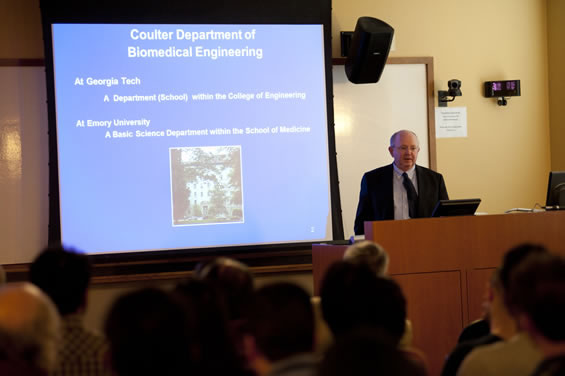 Larry McIntire next to presentation slide