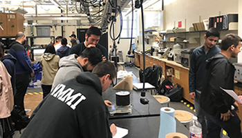 Students in a lab looking at a paper