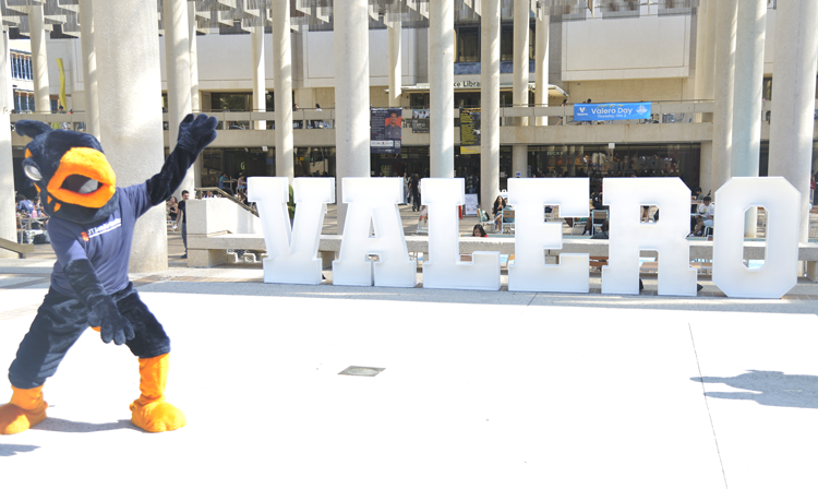 Rowdy standing at a Valero sign