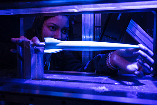 Graduate research assistant Angelina Andrade adjusts a test rocket in the wind tunnel at the UTSA Hypersonics Lab.