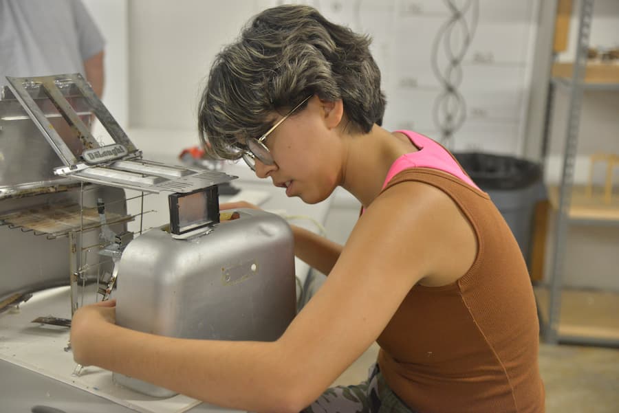 A summer camp participant with their model.