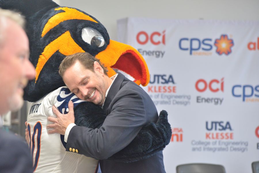 OCI Energy President Sabah Bayatli hugs the UTSA mascot during a $250,000 scholarship donation ceremony at UTSA.