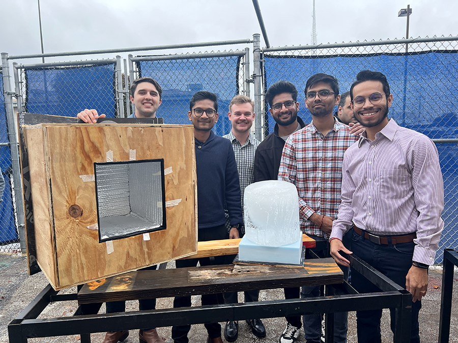 Faculty and students from the Architecture program posing with their Mini Ice-Box Challenge design, showcasing their innovative ice preservation container.