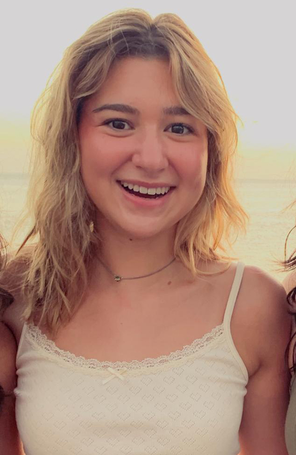 Reese smiling during a sunset with friends, radiating warmth and joy.
