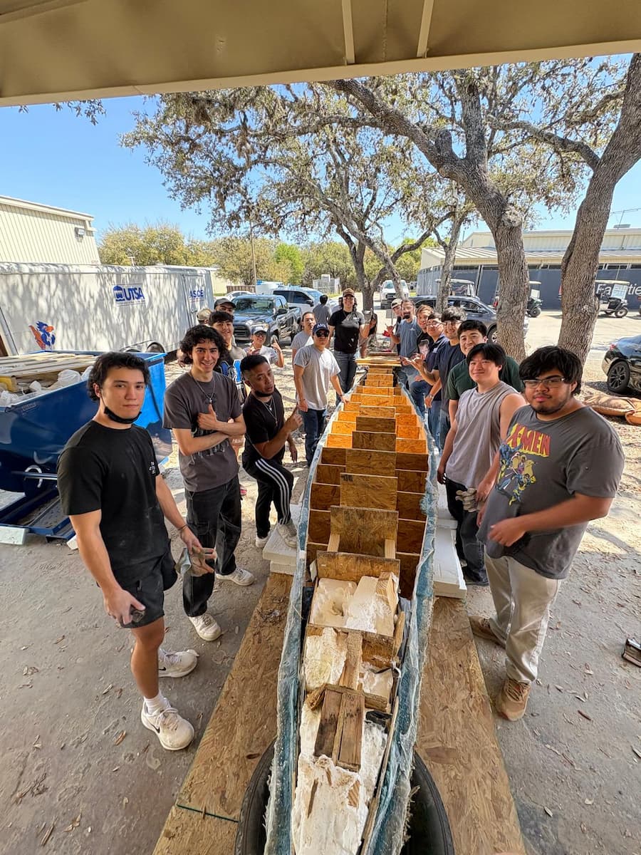 The team standing next to their canoe.