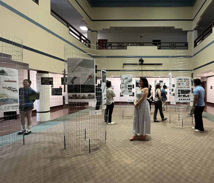 Visitors view student architecture, urban planning, and landscape design projects displayed in the 