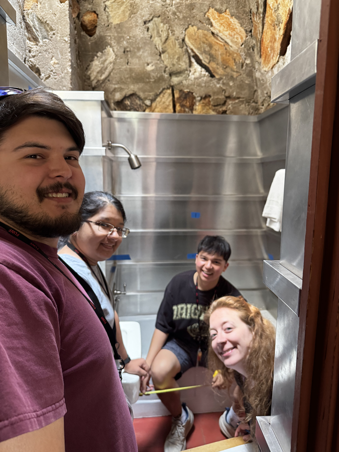 Isaac, Theresa, Hailey, and Daniel, measuring Wright’s aluminum-wrapped batten bathroom.
