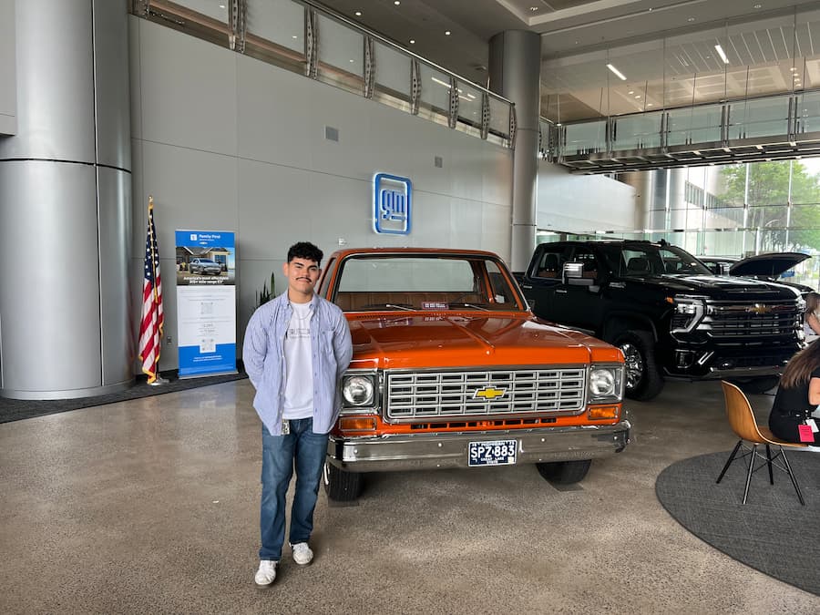 Austin next to a fancy car.