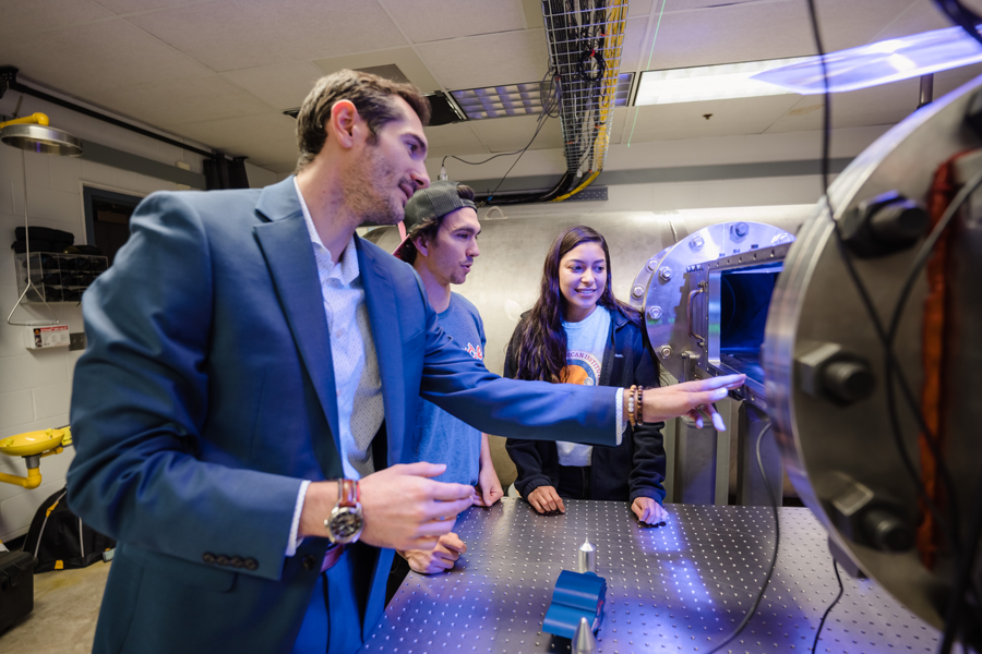 Chris Combs shows a pair of students the Mach 7 wind tunnel.
